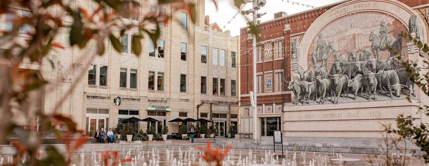 a courtyard with tables and chairs and buildings in the background at Sundance Square Fort Worth